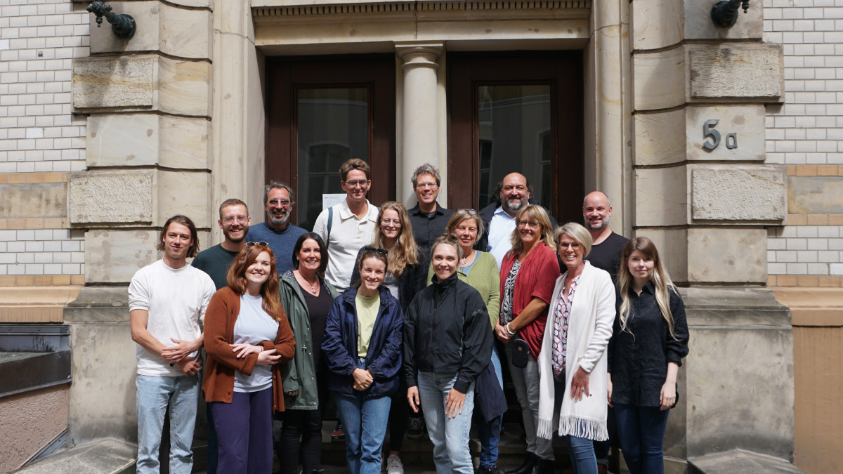 A group of people in front of the Fab City Haus entrance pose for a group photo.
