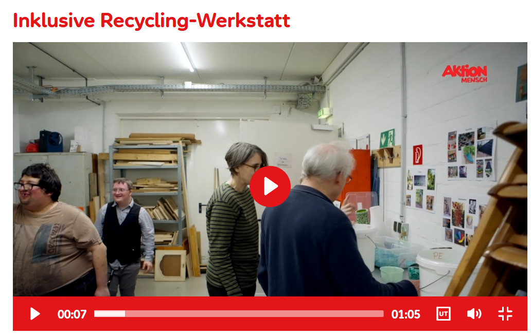 A screenshot of the video contribution to the Insel e.V.. Four people in the workshop. The Aktion Mensch logo is in the upper right corner. In the center a play button. Below the timeline of the video.