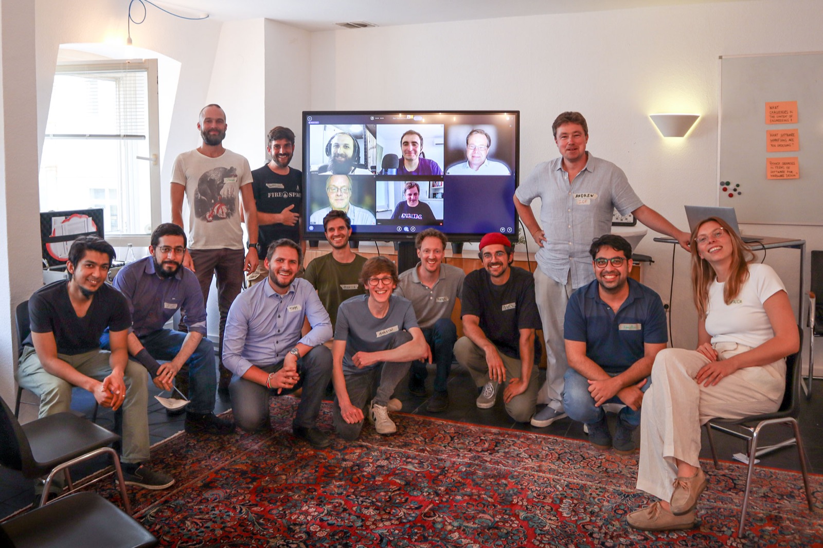 Gruppenfoto mit Mitarbeitern der Open Toolchain Foundation vor einem Monitor